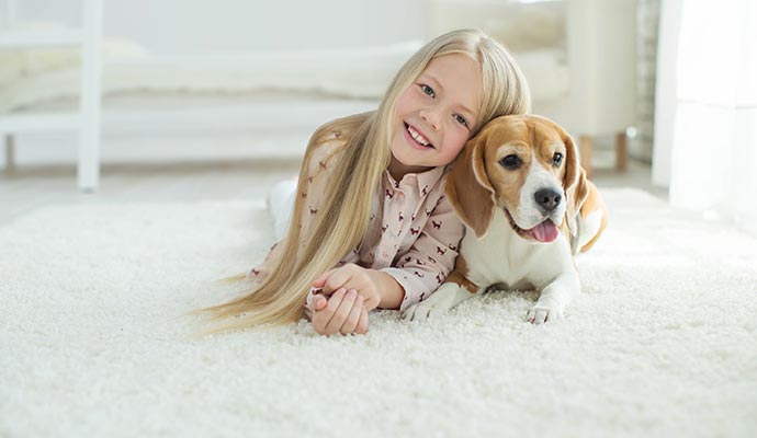 a child with her pet on a clean rug