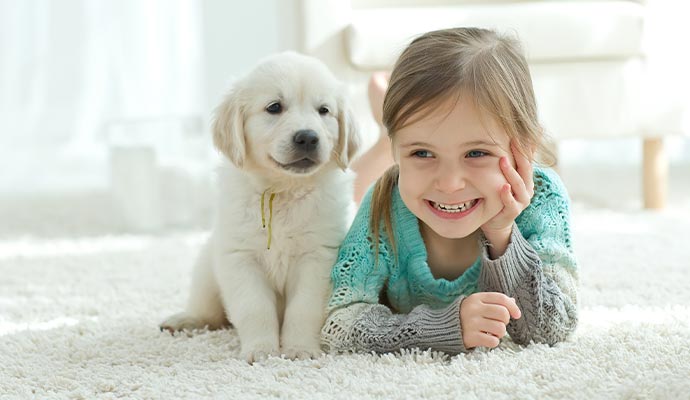 Children with pet dog lying on a clean rug