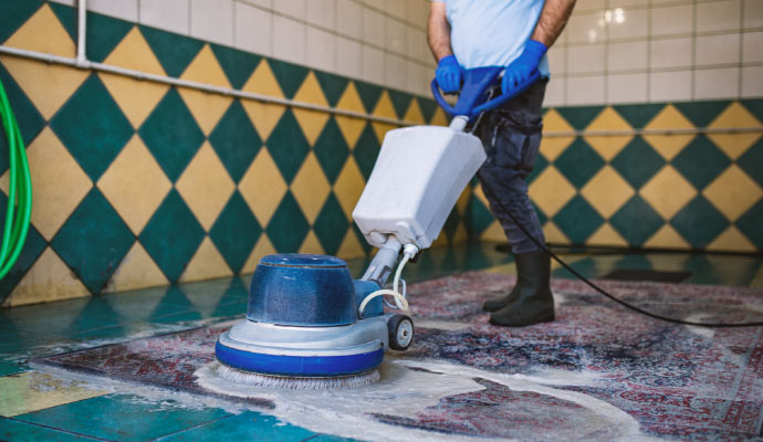 a professional cleaning a rug using professional equipment