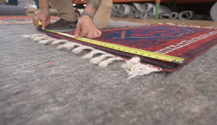 A person measuring a rug