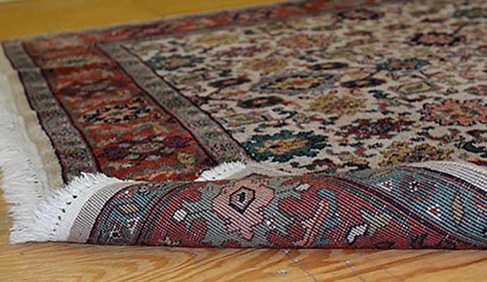 Rolled oriental rug on wooden floor